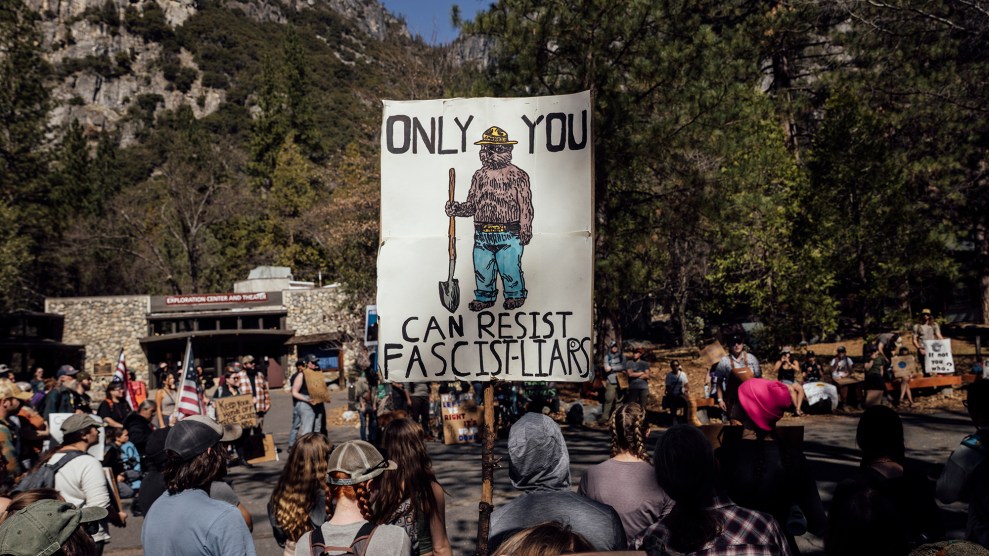 A group of protesters holds a sign with Smokey the Bear that says "Only You can Resist Facism"