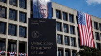 The Department of Labor building with a flag of Trump and an American flag drapping down the building.