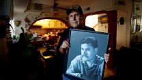 Army veteran Jose Francisco Lopez holds a portrait of himself.