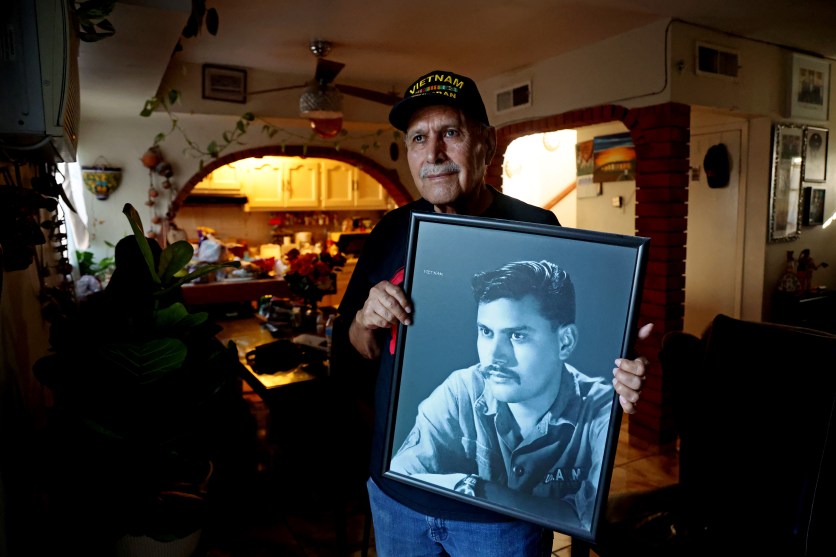 Army veteran Jose Francisco Lopez holds a portrait of himself.