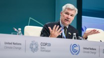 A white man sitting at a table that says "United Nations Climate Change COP29"