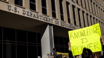 A protest outside the US Department of Education with a sign that says "Knowledge is Power"