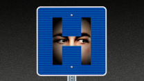 A hospital road sign in which there is a face hidden in the shadows behind the shape of the H. The eyes of the face appear to be staring intently to our right.