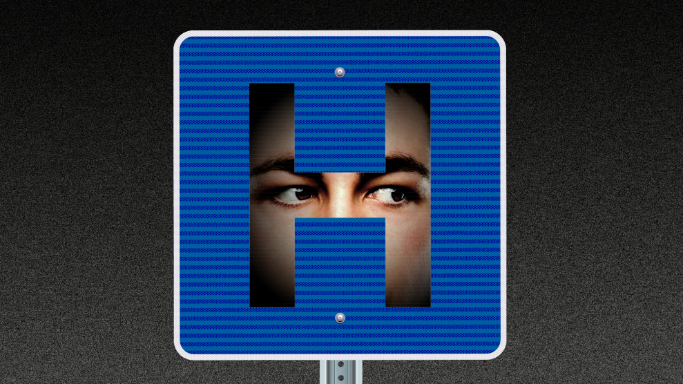 A hospital road sign in which there is a face hidden in the shadows behind the shape of the H. The eyes of the face appear to be staring intently to our right.