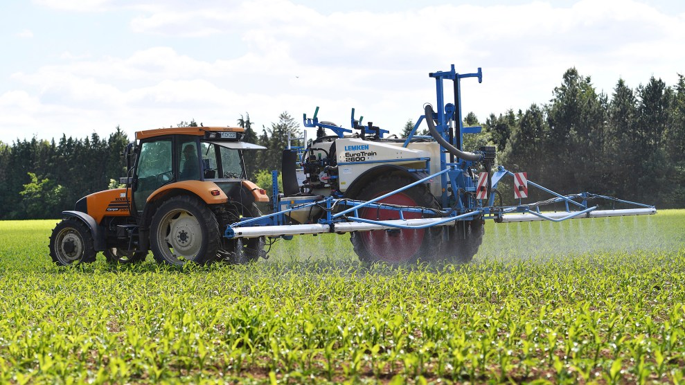 A farmer applies pesticides on a field with a tractor.