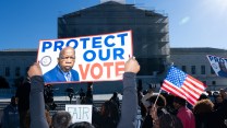 A protestor holds a sign saying "protect our vote" outside the Supreme Court.
