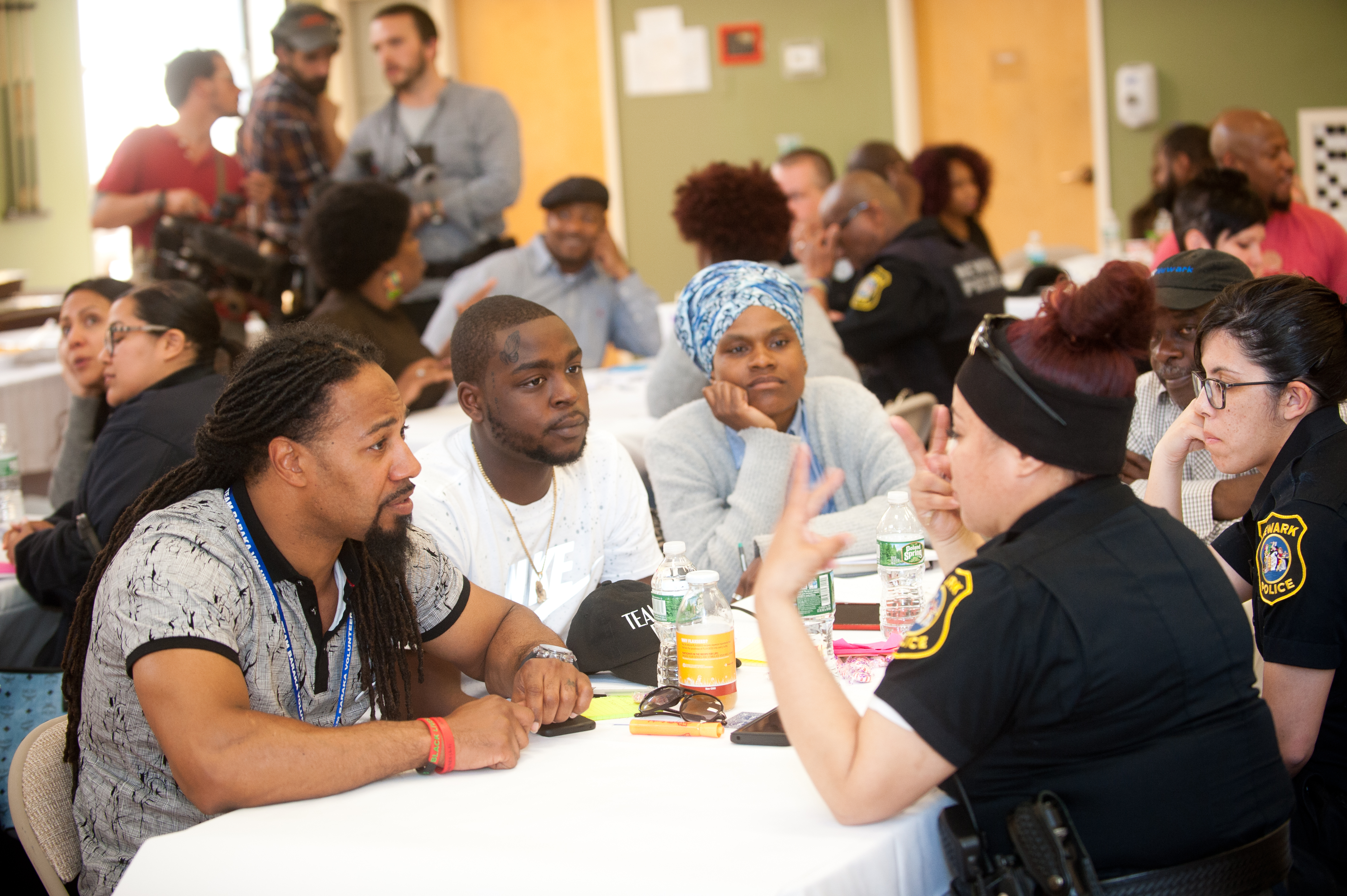Three African American community members engaged in conversation with two female police officers.