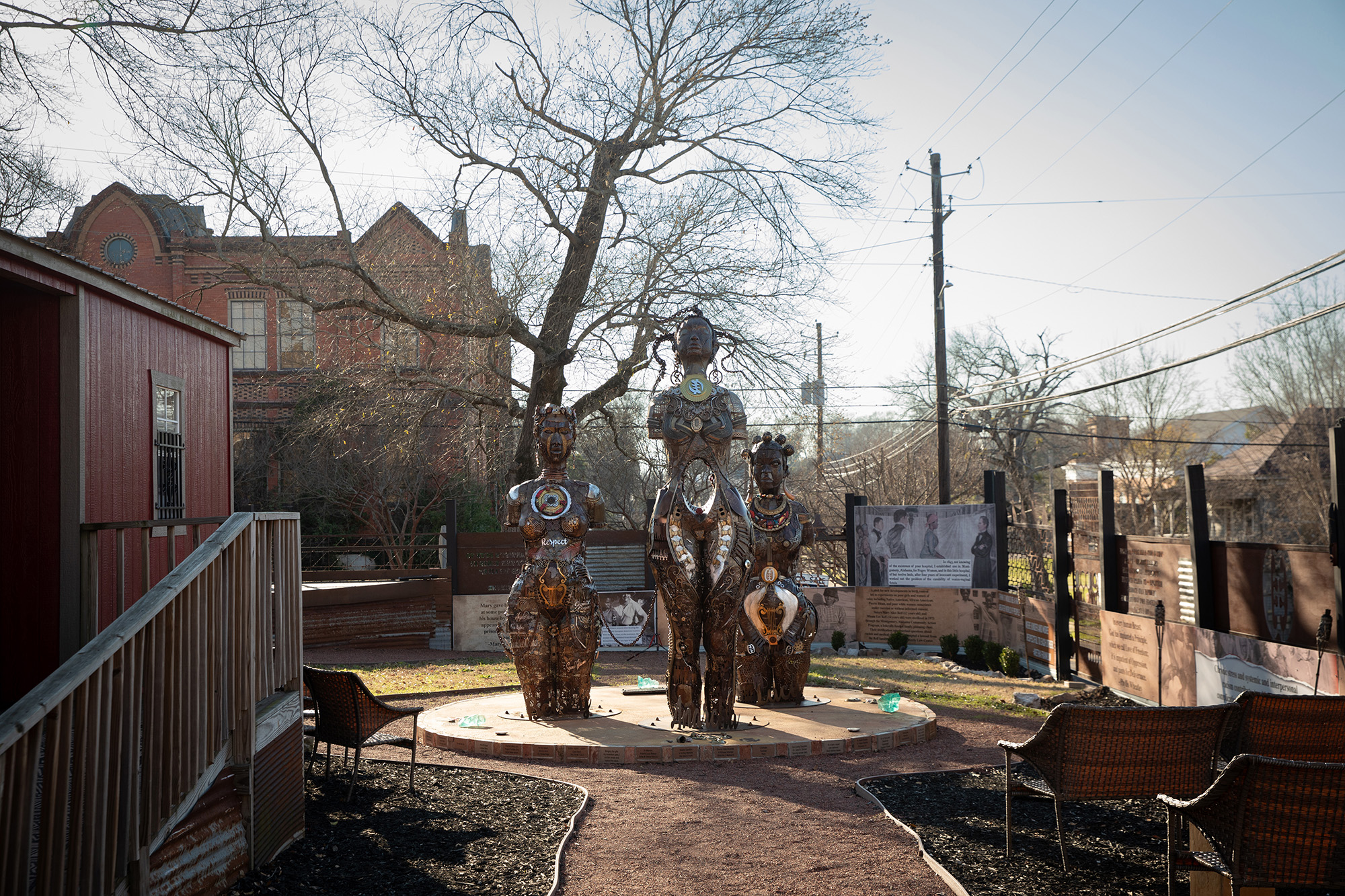 Three metal statues at the end of a walkway.