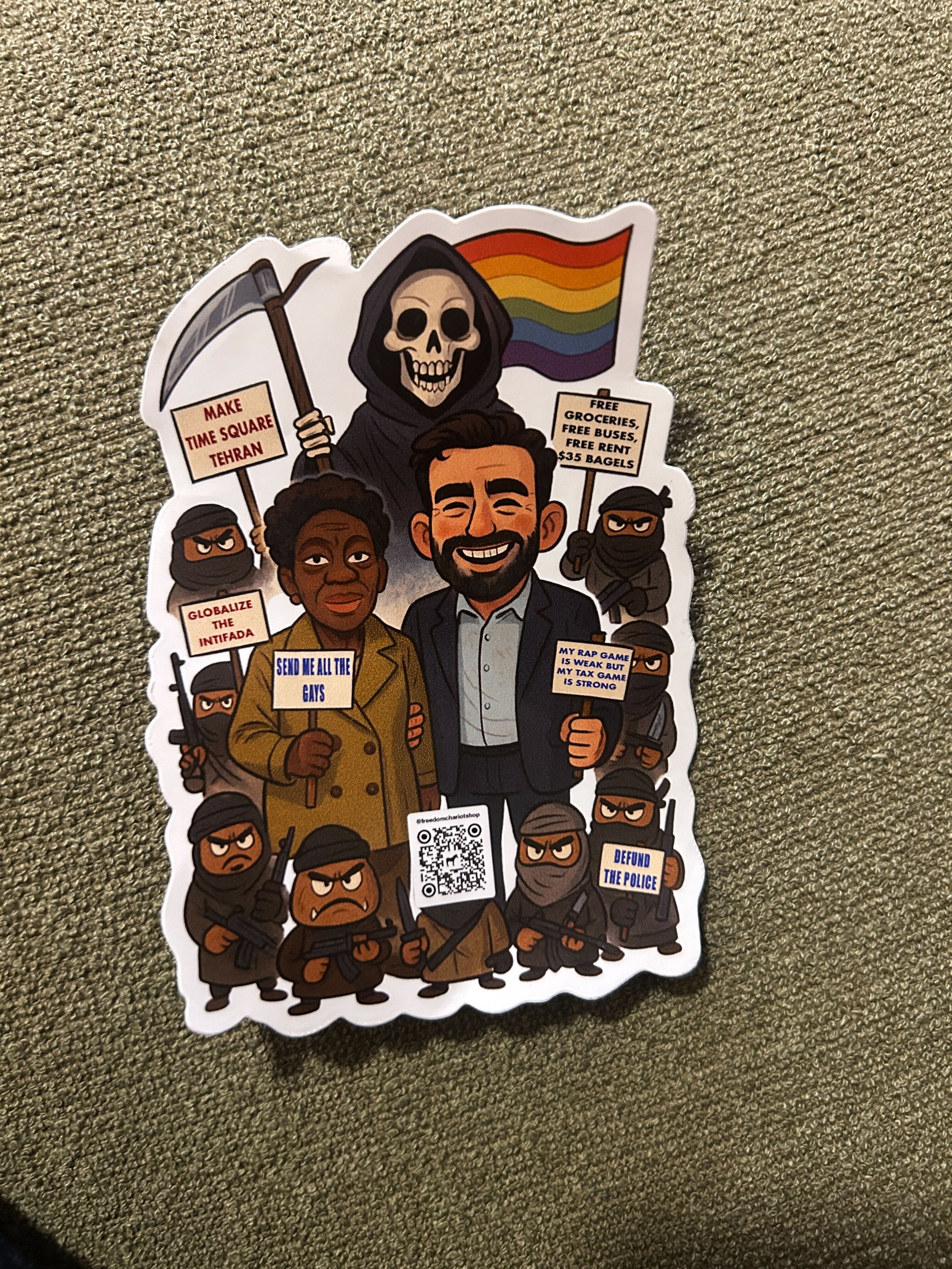 A sticker that shows a cartoon figure of Zohran Mamdani. Around him are other cartoon figures evocative of death with the LGBTQ flag, a black woman, and jihadi terrorists. They hold guns and signs that read "Make Time Square Tehran" and "Globalize the Intifada."