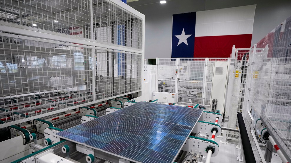 A solar panel in a factory in front of a Texas flag.