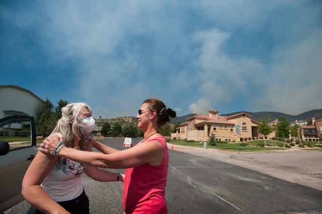 Two residents near the Waldo Canyon fire embrace as smoke rises over their neighborhood.  Mark Reis/Colorado Springs Gazette